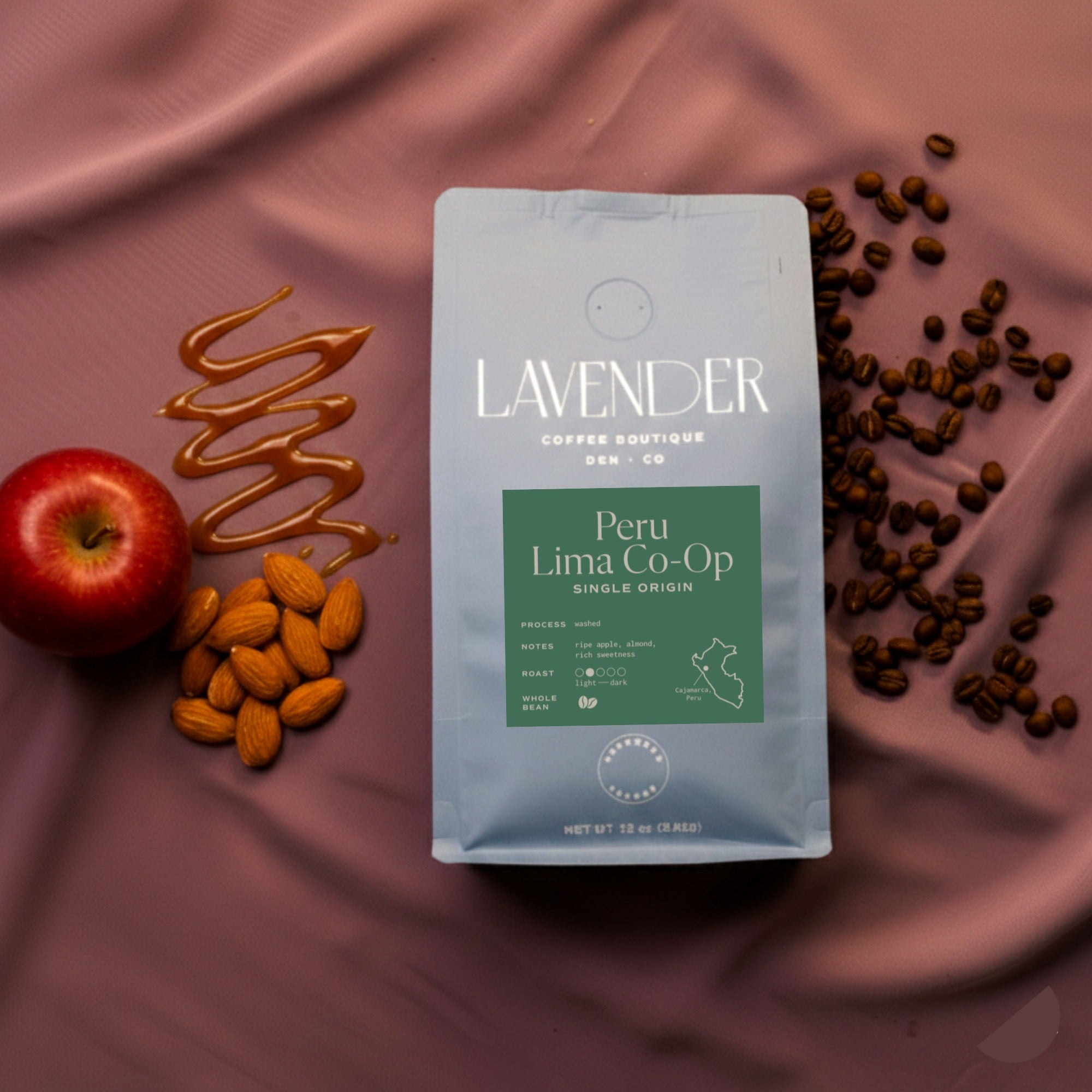 Lavender Coffee Boutique Peru Lima Co-op coffee package with almonds, apple, and coffee beans on a pink fabric background