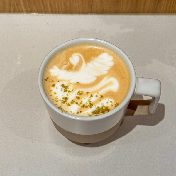Pistachio latte with house-made pistachio syrup and latte art at a Cherry Creek Denver café